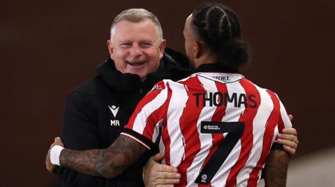 Stoke City boss Mark Robins embraces with Sorba Thomas during the 3-0 win over Charlton