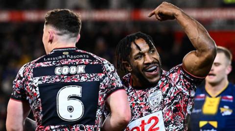 Leigh Leopards player Edwin Ipape celebrates his try against Leeds Rhinos as teammate Adam Cook goes to congratulate him.