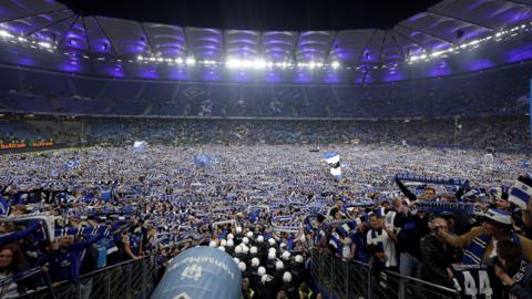 Hamburg fans invade the pitch after winning promotion against Ulm.