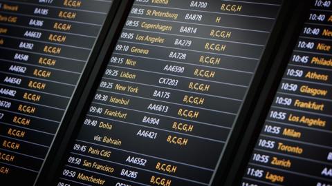 Departure board at Heathrow airport showing flights to New York, LA and others
