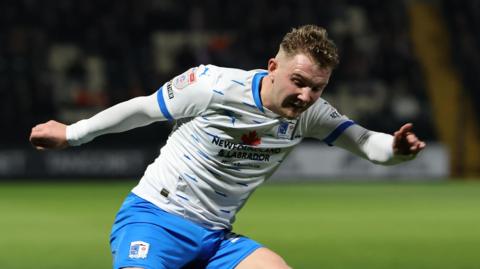 Ben Whitfield putting over a cross for Barrow in a match last season during a loan spell from Burton