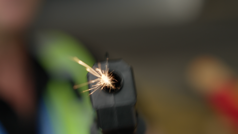 Toy gun aimed at the camera showing sparks coming out of the barrel