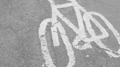 A cycle route road sign painted in white paint onto a road.