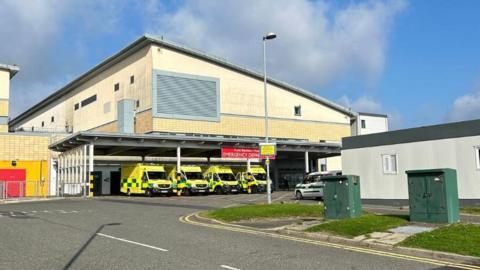 Outside the entrance to Royal Blackburn Hospital's emergency department showing four ambulance parked outside the building