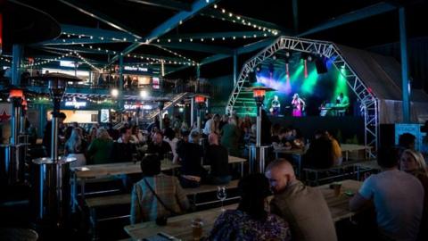 A shot of a STACK leisure complex, showing shipping containers repurposerd as street food venues and seating