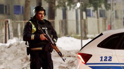 A police officer stands guard at a check point on the outskirts of Cetinje, on January 1, 2025, after a gunman killed several people in the nearby village of Bajice