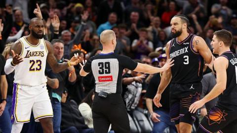 An official comes between Lebron James and Dillon Brooks