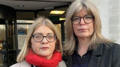 Fiona Elias, left, and Liz Hopkin. They both have spectacles and blond hair. Ms Elias has a beige jacket and red scarf. Ms Hopkin has a dark jacket with a blue and black top beneath it.