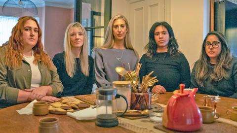 Five bereaeved mothers sitting around a dining room table