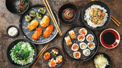 An aerial shot of lots of plates of sushi.