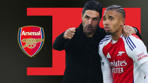 Mikel Arteta, talking to and with his arm round Gabriel Jesus, in front of the red and black background and the Arsenal club badge