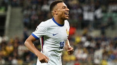 Kylian Mbappe smiles widely after scoring for France against Ukraine