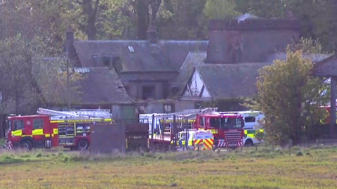 Police, fire and ambulance vehicles parked near buildings near the scene of the crash