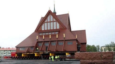 Kiruna's historic wooden church sits on a wheeled transportation unit before being moved to a new site in Kiruna, Sweden 
