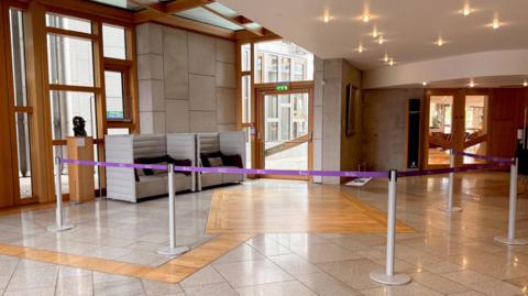 An area of a Scottish Parliament lobby cordoned off by purple tape