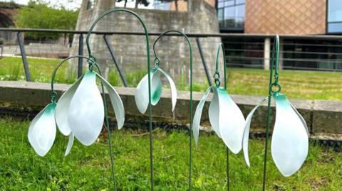 Metal snowdrop sculptures spray-painted white and green