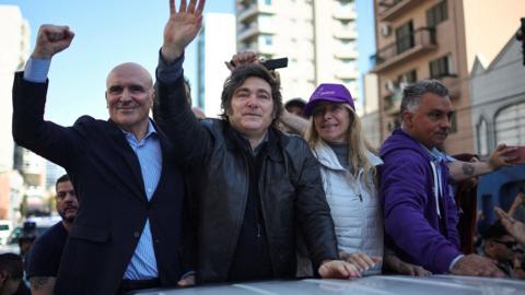 Milei with others standing in the truck