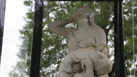 Marble memorial statue of a mother holding the body of a dead child