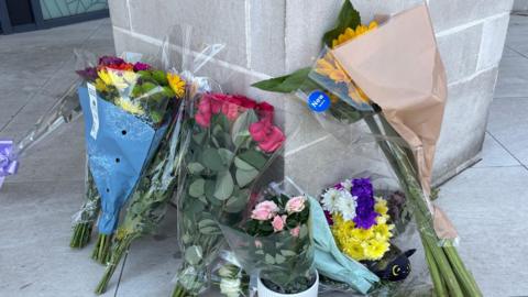 Flowers left at the entrance to a flat.