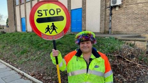 Lollipop lady holding lollipop sign