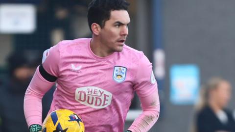 Lee Nicholls in action for Huddersfield in a pink goalkeeper jersey