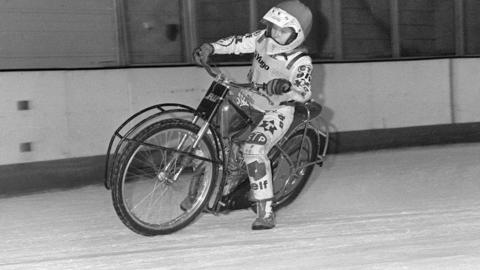 Ice Speedway at Telford ice rink in January 1988. A black and white photo of a motorcycle rider on the ice. They are wearing a helmet and cycling suit. 