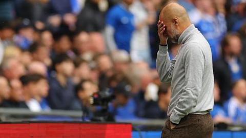 Pep Guardiola holding his face