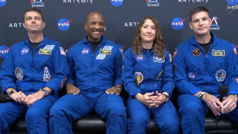 NASA astronauts Reid Wiseman and Victor Glover greet each other next to NASA astronaut Christina Koch and CSA (Canadian Space Agency) astronaut Jeremy Hansen.