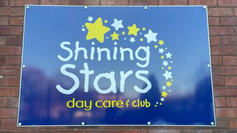 A bright blue sign with the words "Shining Stars" written across in big white letters.