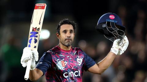 Ravi Bopara with his bat aloft in his right hand and his helmet in his left after scoring a century for Northants against Surrey at The Oval