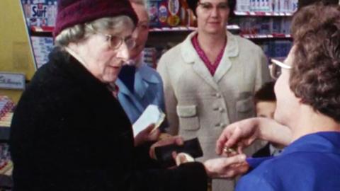 Archive image of an elderly woman receiving some coins in a shop