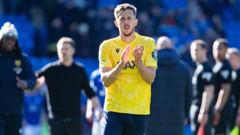 Will Vaulks of Oxford United applauds supporters
