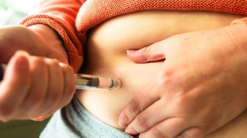 Llun rhywun yn defnyddio meddyginiaeth colli pwysau