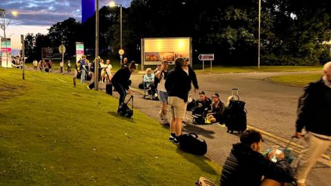 Stranded travellers waiting outside the airport