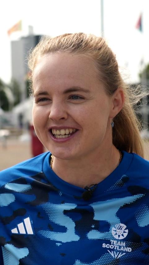 A head and shoulders shot of a smiling woman with blonde hair and a blue camo Team Scotland top on.