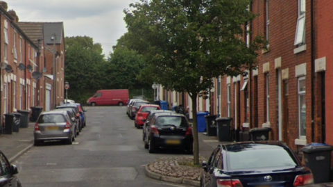 A Derby one way street with a tree growing in a chicane