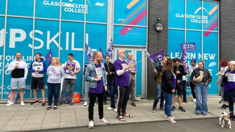 College lecturers on strike with flags and posters outside Glasgow Clyde college