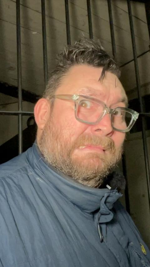 A man wearing glasses looks scared.