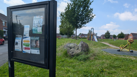 A boulder on the green area in Weston Heights