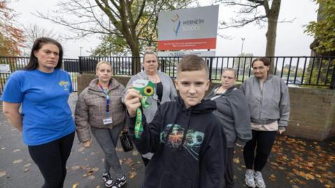 A picture of student Finlay and some parents outside Werneth School on Harrytown road in Stockport