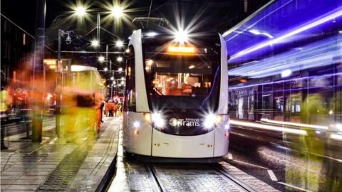 Bright lights of a tram at a tram stop.