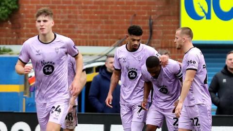 Lincoln players celebrate a goal at Mansfield