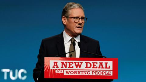 Sir Keir Starmer giving a speech at the Trade Union Congress in Brighton, behind a podium reading: "A new deal for working people". 