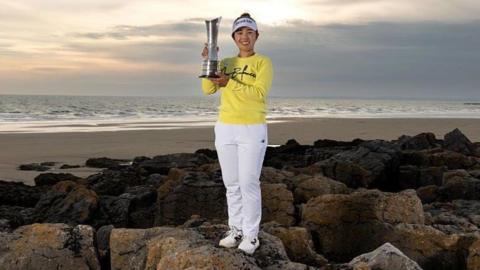 Miyu Yamashita holds her trophy at the Porthcawl coastline 