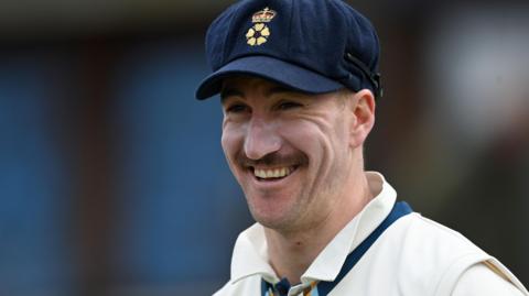 Blair Tickner smiles while in action for Derbyshire