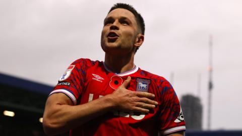 George Hirst taps the Ipswich Town badge on his shirt after scoring