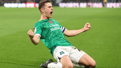Adam Randell slides on his knees after scoring for Plymouth