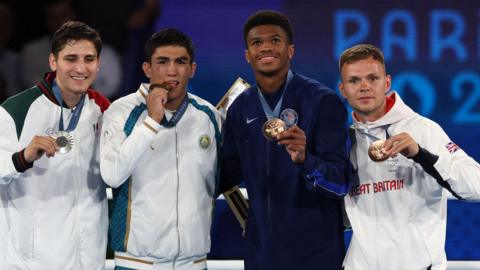 Gold medallist Asadkhuja Muydinkhujaev of Uzbekistan, silver medallist Marco Alonso Verde Alvarez of Mexico, bronze medallist Omari Jones of the United States and bronze medallist Lewis Richardson of Great Britain pose with their men's 71kg boxing medals at the Paris 2024 Olympics