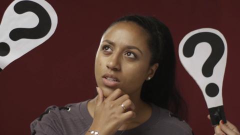 A young woman thinking, with a question mark on either side of her. 