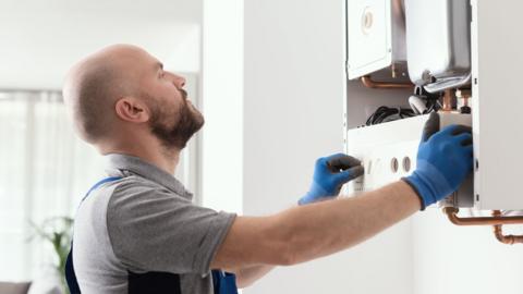 Professional qualified engineer testing a gas boiler after repair
